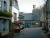 Concarneau - Calle bordeada de hermosas casas de piedra con persianas azules y un restaurante con terraza