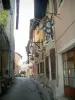 Conflans medieval town - Gabriel-Pérouse street with its houses with forged iron shop sign (banner)