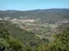 Corbières - Vista del pueblo rodeado de verdes colinas Cucugnan