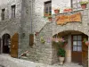 Couvertoirade - Каменный фасад украшен цветами