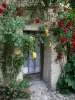 Dauphin - Porte d'une maison ornée de roses rouges et jaunes (rosiers grimpants)