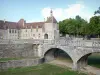 Époisses castle - Bridge spanning the dry moat and facade of the castle with its Brunehaut tower