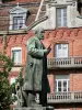 Familisterio Godin - Estatua de Jean-Baptiste André Godin, creador de Familistery de Guisa, y la fachada de ladrillo de la izquierda de la Familistery (social palacio) en Thiérache