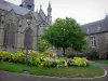 Fougères - Saint Léonard church, town hall and public garden with tree, lamppost, lawn and flowers