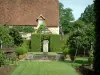Gardens of the Notre-Dame d'Orsan priory - Cloister garden of medieval style with the four-jet fountain, plants, trees and the ancient monastery in background