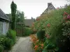Gerberoy - Flower-bedecked narrow paved street (rosebushes, flowers, plants) and houses of the village
