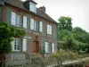 Gerberoy - Brick and stone house with white shutters, trees and forged iron fence with rosebushes (roses)