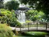 Jardin botanique de Deshaies - Cascade, végétation tropicale et petit pont de bois enjambant le bassin