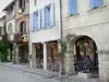 Labastide-d'Armagnac - Fachadas de casas en la Place Royale y la terraza de un café bajo las arcadas