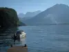 Lac d'Annecy - Ponton en bois, lac, bateau à moteur et montagnes couvertes de forêts