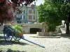 Lacaune - Paved square with wooden wheelbarrow decorated with flowers, fountain, trees and stone houses (Upper Languedoc Regional Nature Park)