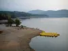 Lago de Saint-Cassien - Playa, árboles, barca a pedales amarillo amarrado a un pontón, lago, costa y las colinas boscosas