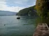 Lake Annecy - Pontão de madeira, lago, barco (veleiro), árvores e colinas cobertas de florestas