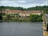 Lalinde - Houses of the fortified town, trees and bridge spanning the River Dordogne, cloudy sky, in the Dordogne valley
