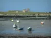 Landscapes of the Brittany coast - Low tide with small colourful boats and bank in background