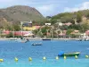 Landscapes of the Guadeloupe - Les Saintes: view of the steeple of the Notre-Dame-de-l'Assomption church, the houses of the Terre-de-Haut island and boats floating on the sea