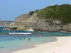 Landscapes of the Guadeloupe - Beach of the Laborde cove, on the island of Grande-Terre, in the town of Anse-Bertrand: sandy beach and bathers cooling off in the turquoise waters of the sea, views of the cliffs