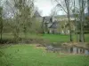 Landscapes of the inland Brittany - In a meadow with a river, a beautiful stone residence surrounded by trees