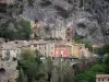 Lanscapes of Alpes-de-Haute-Provence - Village of Moustiers-Sainte-Marie: bell tower of the Notre-Dame-de-l'Assomption church, houses, cliff (rock face) and Stations of the Cross leading to the Notre-Dame-de-Beauvoir chapel; in the Verdon Regional Nature Park