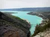 Lanscapes of Alpes-de-Haute-Provence - Emerald-coloured Sainte-Croix lake (water reservoir) and its shores, rock face in foreground; in the Verdon Regional Nature Park