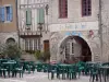 Lauzerte - Bastide médiévale : façades de maisons et terrasse de café de la place des Cornières