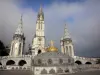 Lourdes - Domaine de la Grotte (santuarios, ciudad religiosa): cúpula de la Basílica de Nuestra Señora del Rosario con una corona y una cruz de oro, torres y el campanario de la Basílica de la Inmaculada Concepción (Iglesia de arriba) neogótico