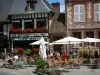 Lyons-la-Forêt - Terrasse de café, décorations florales (fleurs) et façades de maisons du village