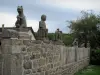 Masgot - Mur en pierre surmonté de sculptures