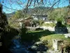 Megève - Las ramas de un árbol en primer plano, ríos y casas en la estación de deportes de invierno y verano