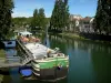 Melun - River Seine, moored barge, restaurant terrace, banks of the River Seine, facades of the city and trees along the water