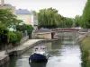 Montargis - Boat navigating the canal, houses and trees