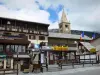 Montgenèvre - Ski Resort (estación de esquí de invierno y verano): iglesia de campanario San Mauricio con su linterna, casa rural, banderas francesas y de las tiendas