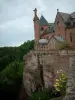 Mount Sainte-Odile - Convent (monastery) at the top of the pink sandstone cliff, wild flowers and trees in the forest below