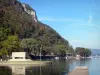 Nantua lake - Monument to the deportees of the Ain, and mountains covered with trees overlooking the lake; in Upper Bugey 