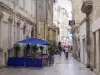 Nîmes - Alleyway in the old town: cafe terrace, shops and facades of houses