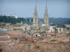 Nîmes - Ver sobre los tejados de la ciudad vieja y los dos campanarios rematada torres de la iglesia de San Baudilo