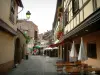 Obernai - Calle peatonal con casas llenas de flores y cafés al aire libre