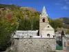 Oisans - Saint-Ferréol church in Huez and mountain covered with trees with autumn colors