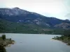 Paisajes de la Córcega interior - El agua de la cuenca (lago de la presa) Calacuccia, árboles, bosques y montañas en el fondo