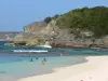 Paisajes de Guadalupe - Laborde playa de cala en la isla de Grande - Terre, en la ciudad de Anse - Bertrand : arena y los bañistas se refrescan apagado en las aguas turquesas del mar, con vistas a los acantilados