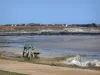 Paisajes de Normandía - Costa de la península de Cotentin: banco con vistas a la playa, techos de las casas en el fondo
