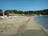 Pampelonne beach - Bay of Pampelonne in Ramatuelle: sunbeds and parasols on the Tahiti beach (sandy beach), the Mediterranean Sea, palm trees and pine forest