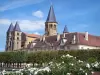 Paray-le-Monial - Basílica del Sagrado Corazón (edificio romano), con sus torres cuadradas y su campanario octogonal, alineación de ejes y rosas blancas (rosas) en el primer plano