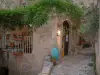 Pigna - La entrada a un hotel decorado con flores y una enredadera (Balagne)