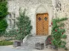 Pompadour castle - Door and facade of the castle decorated with climbing roses in bloom