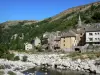Le Pont-de-Montvert - River Tarn, bell tower of the church and facades of houses in the village; in the Cévennes National Park