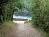 Presa de Éguzon - Arbolada carretera que conduce al punto de vista de la presa, el agua (lago o lago Chambon Éguzon) en el fondo