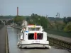 Puente-canal de Briare - Barco de pasar la vía del puente del canal, caminos de sirga y farolas, árboles y casas en el fondo