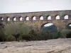 Puente del Gard - Acueducto romano (monumento antiguo) y los árboles en la ciudad de Vers-Pont-du-Gard