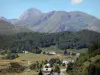 Pyrenees landscapes - Houses surrounded by pastures, forests and mountains, peak of Pic du Midi de Bigorre in the background